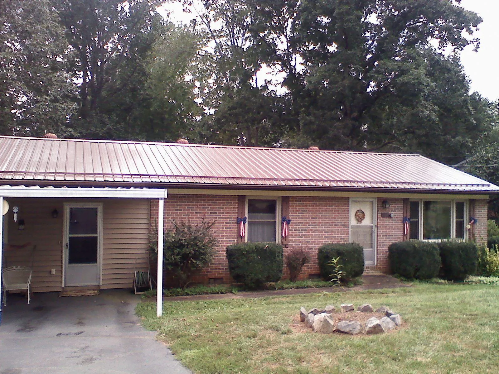 Bronze metal roof and carport on a brick ranch home — Roof Repair work by our crew in Unionville